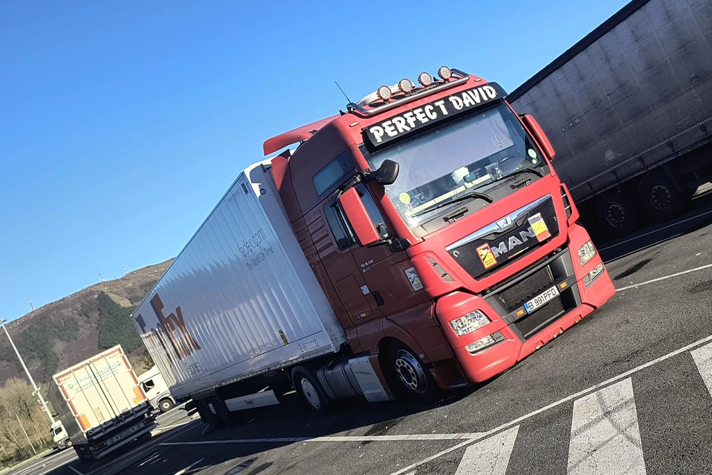 Camion MAN si semiremorca duba box asteptand in parcare